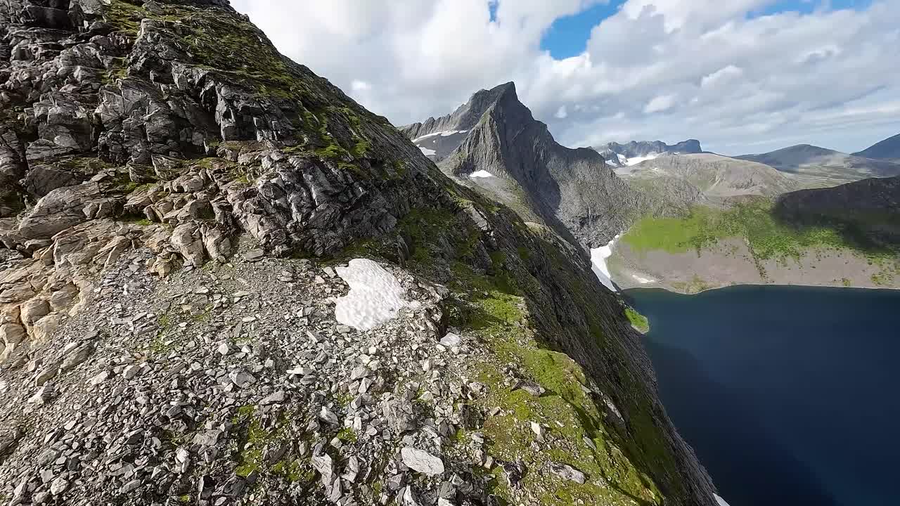 subiendo y sumergiéndose, un dron fpv explora lagos de montaña ubicados en medio de picos altísimos, capturando la esencia de la serena naturaleza salvaje