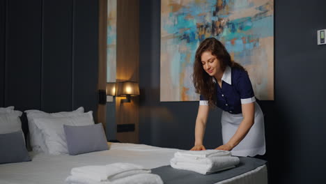 a maid in a hotel room making the bed.