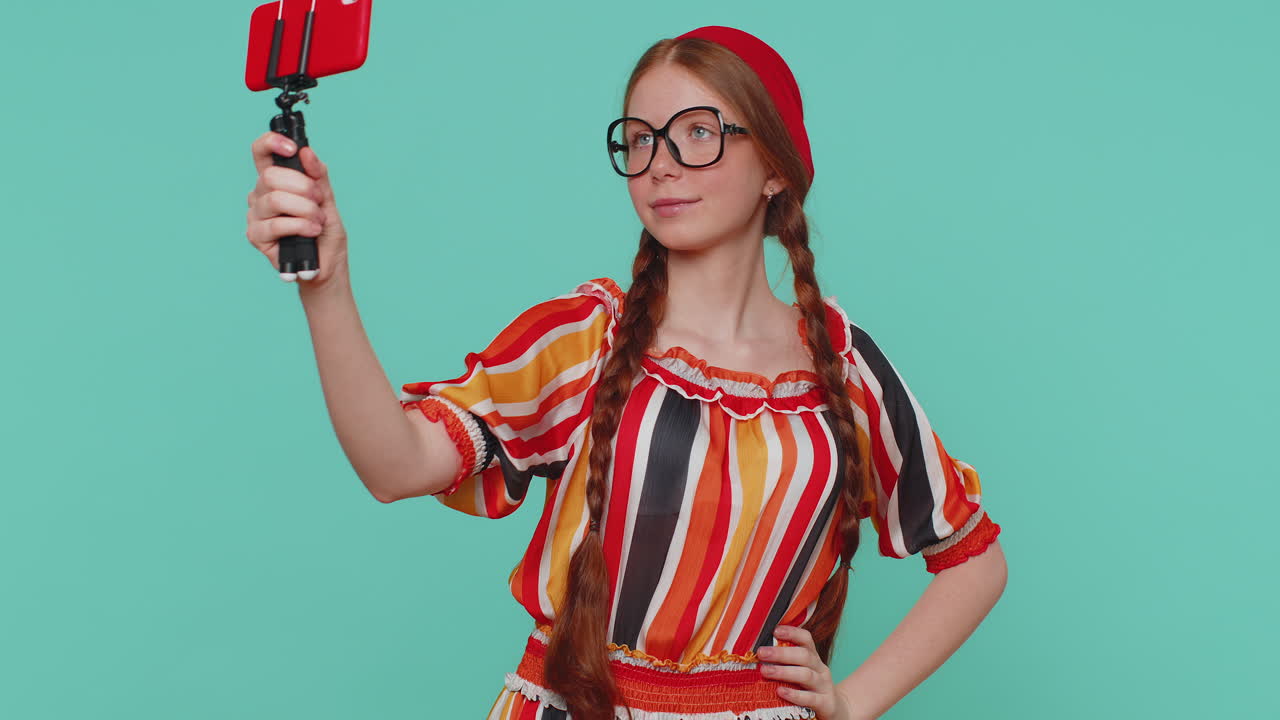 blogger chica tomar selfie en el teléfono móvil selfie stick comunicarse llamada de video en línea con los suscriptores