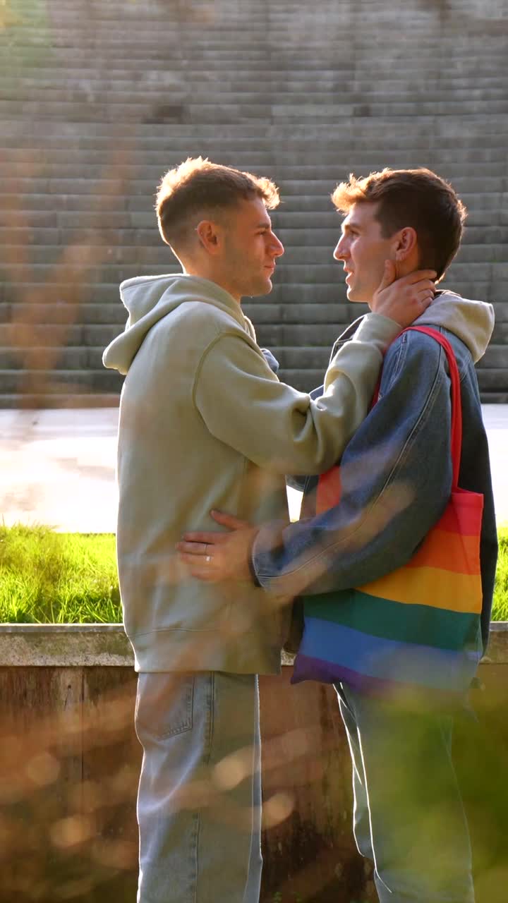 Coppia gay che si abbraccia con borsa arcobaleno