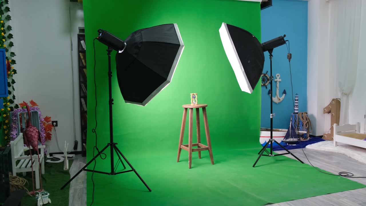 estudio de fotos o video con dos luces de estudio hexagonal. reloj de arena en cortina verde y silla fija
