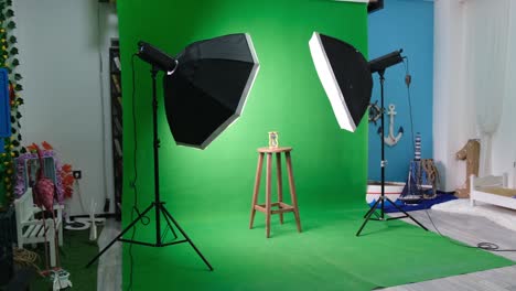 photo or video studio with two hexagone studio lights. hourglass on green curtain and fixed chair