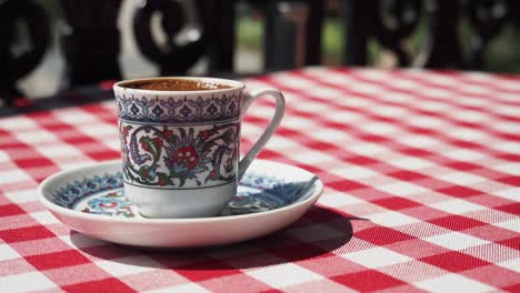 turkish coffee cup on checkered tablecloth