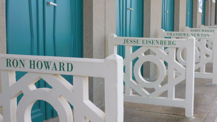 Shot of famous beach cabins with celebrity names who came for the festival throughout the years on waterfront in Normandy town, Deauville, France at daytime