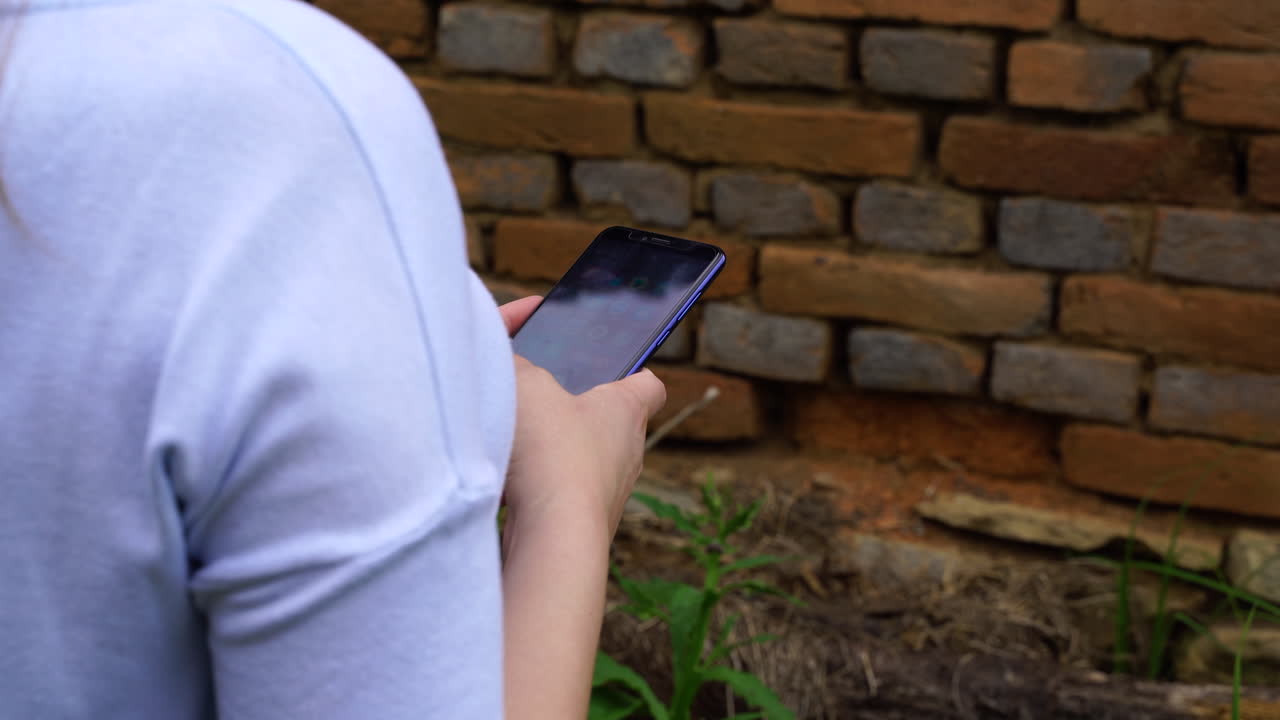 파란색 옷을 입은 여자가 손에 전화기를 들고 있다