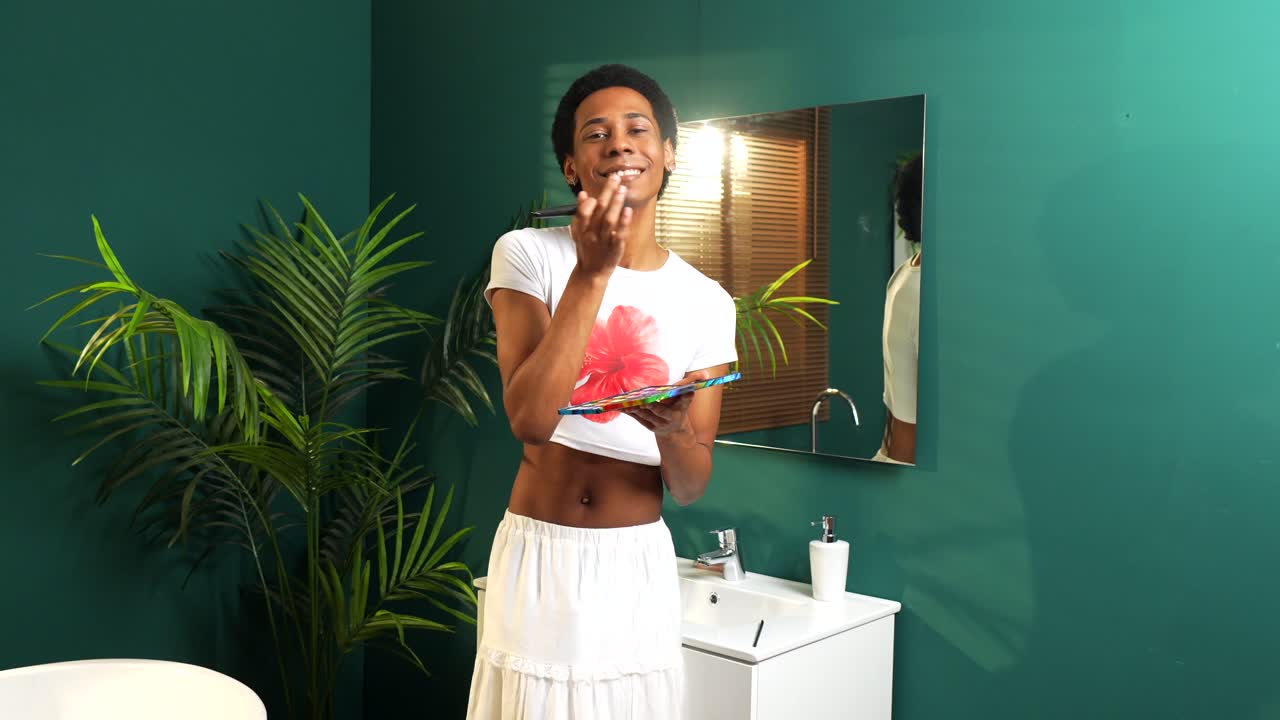 Homme se maquillant dans une salle de bain
