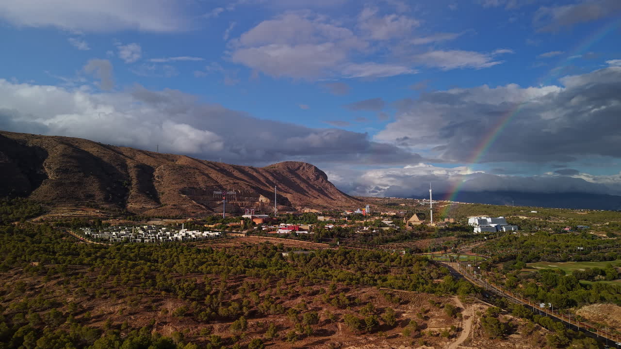 Vista aerea della periferia di Benidorm con montagne, paesaggio rurale, strada e arcobaleno dopo la pioggia nella Spagna mediterranea