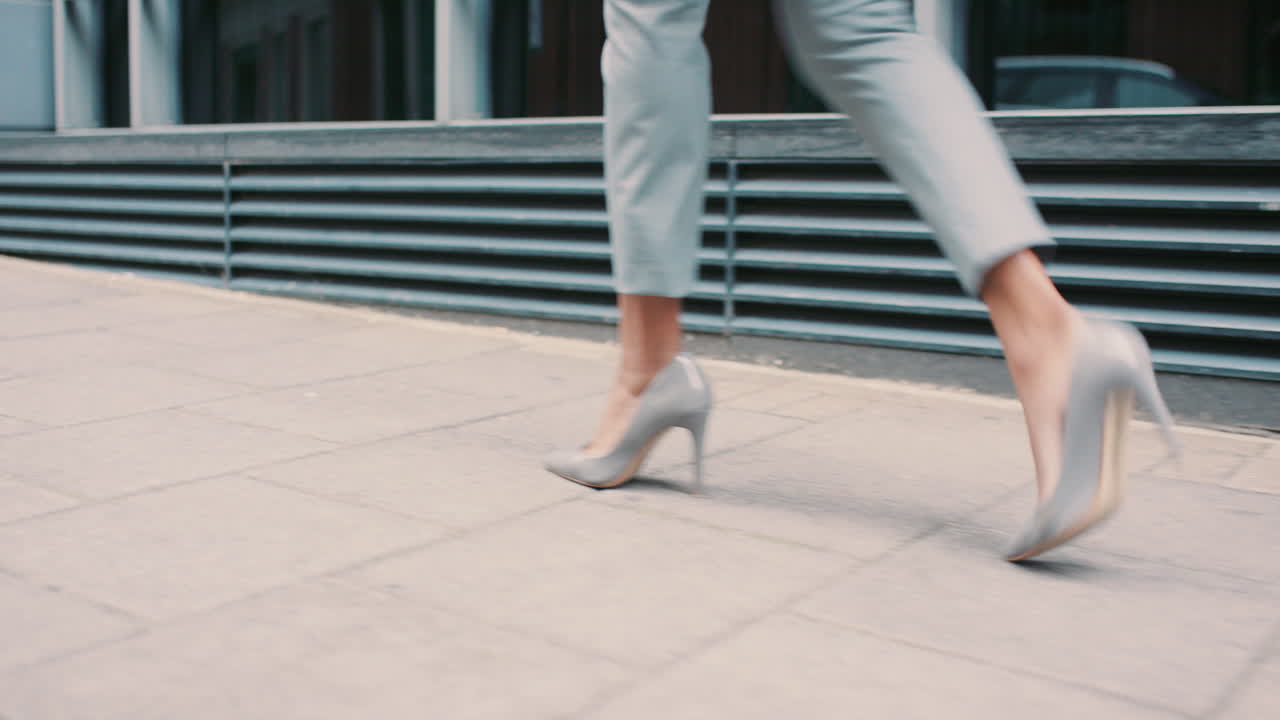 Beautiful mixed race business woman's feet walking through city