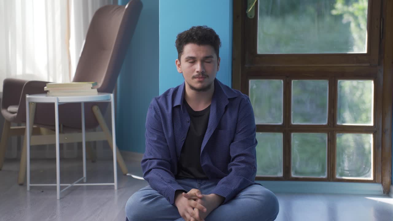 바닥에 앉아 있는 남자가 울고 있다. 절망하고 있다.