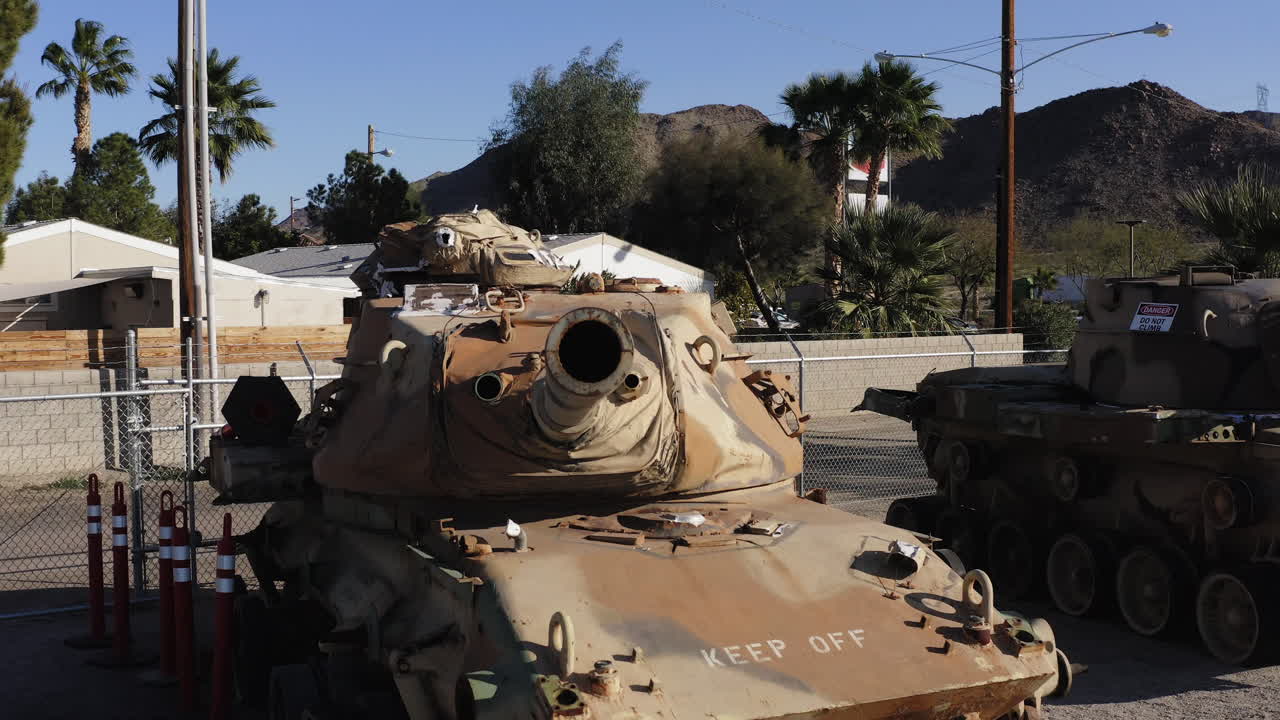 Carro armato in esposizione in un museo con sfondo desertico, che evoca la storia militare.