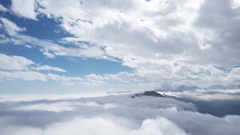 aerial drone view of layers of clouds in the sky over mountains