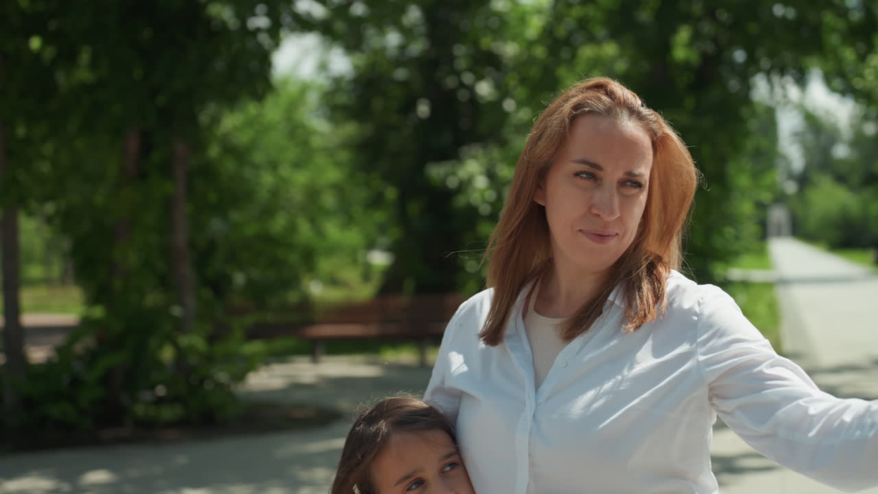 Genitore osserva la natura. Madre e figlia esplorano l'aperto. La bambina impara attraverso la madre nell'ambiente del parco. Madre e sua figlia curiosa investigano una foglia vibrante durante una passeggiata nella natura.