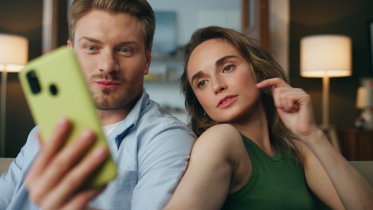 가제트를 사용하는 사랑의 커플 쾌적한 집. 여성이 남자에게 드폰을 보여줍니다.