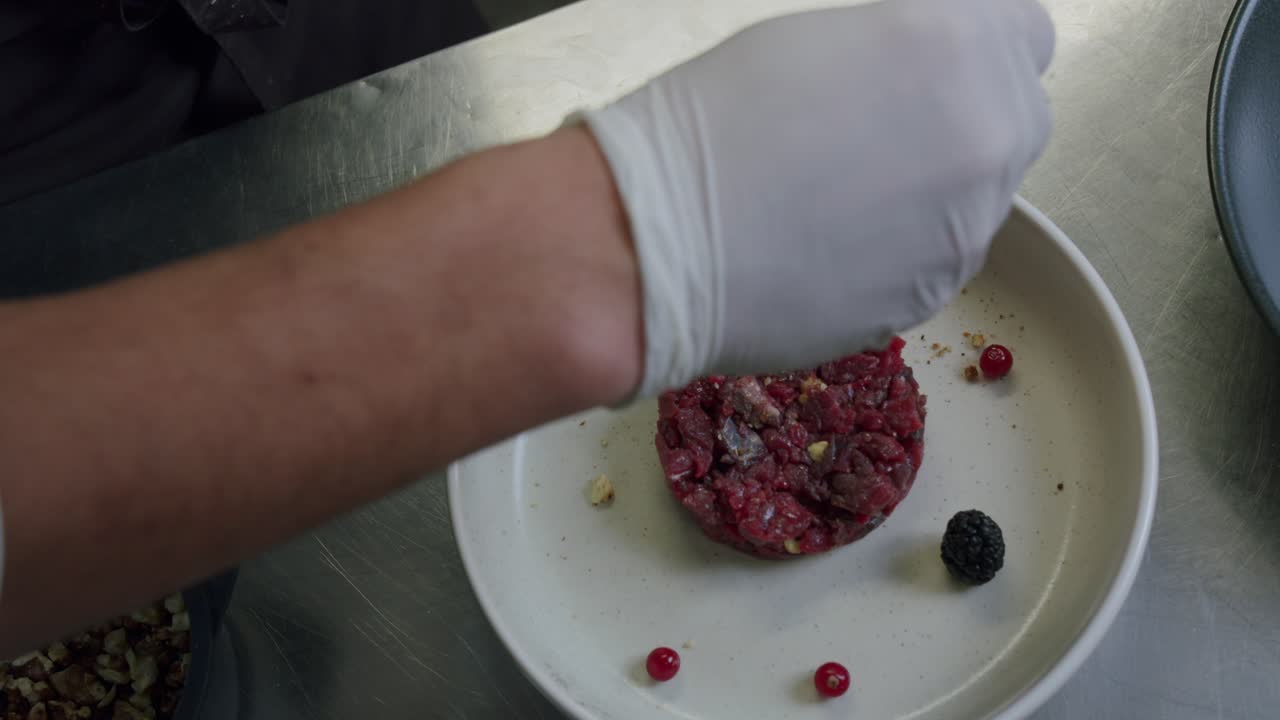 un chef italiano profesional está preparando un plato de tartar de ternera en su cocina