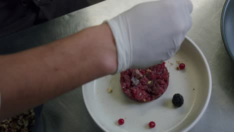 A-professional-Italian-chef-is-preparing-a-plate-of-beef-tartare-in-his-kitchen