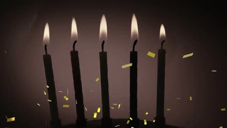 confeti dorado cayendo sobre la silueta de varias velas encendidas contra un fondo gris