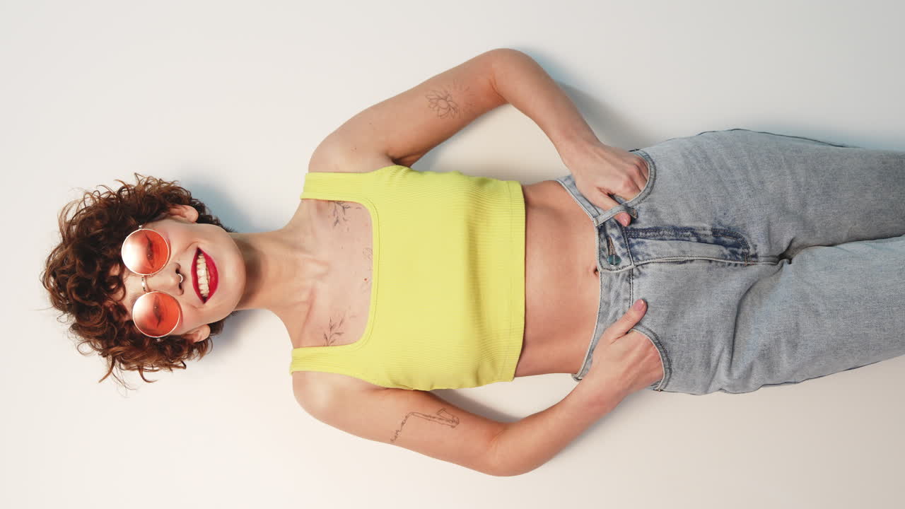 Donna con top giallo e jeans e occhiali da sole