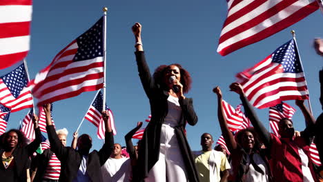 speaker addressing a patriotic crowd with american flags