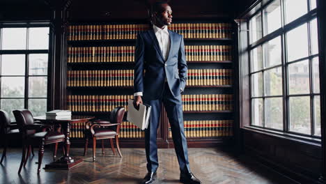 a professional man in a suit standing in a library