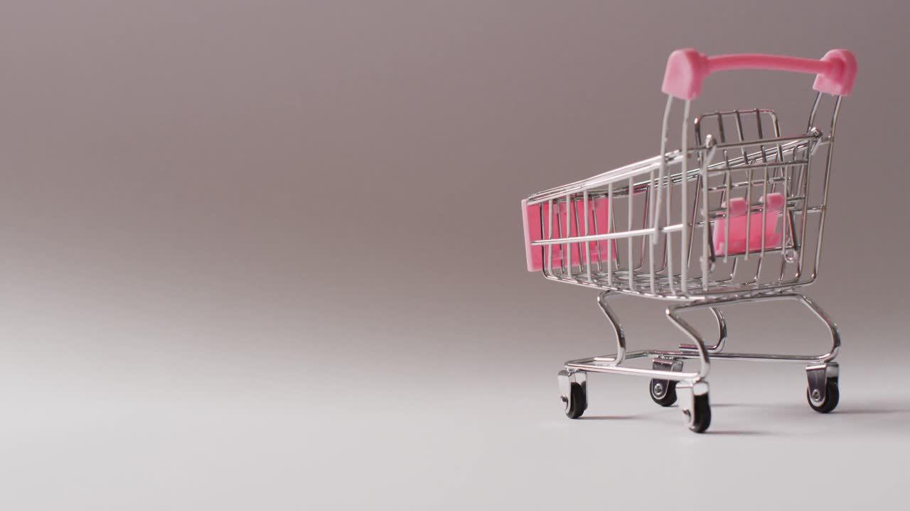 빈 분홍색 쇼핑 트롤리 가 매 없는 회색 배경 에