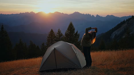 woman camping in the mountains at sunrise