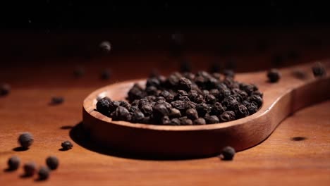 Schwarze-Tellicherry-Pfefferkörner-Closeup-In-Holzlöffel-Auf-Einem-Küchentisch.