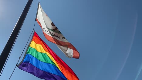 lgbt pride flag and california state flag waving together to celebrate lgbt pride month