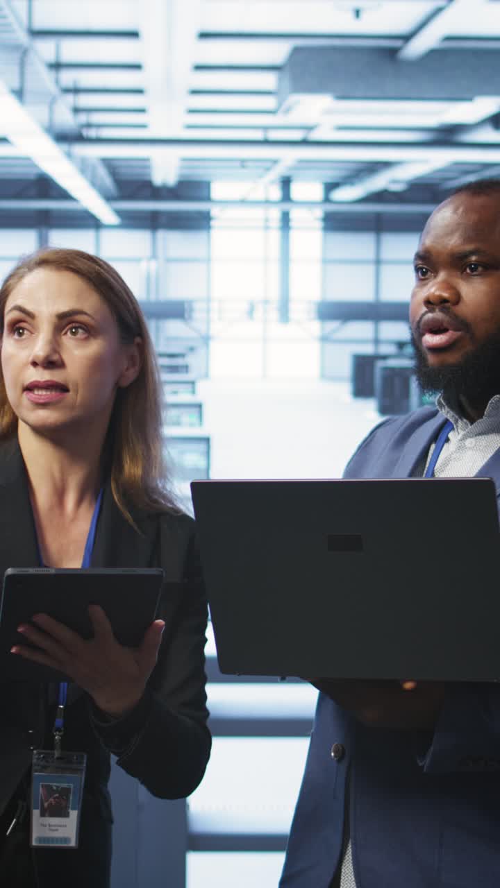 Tecnici IT discutono delle operazioni del data center con laptop e tablet