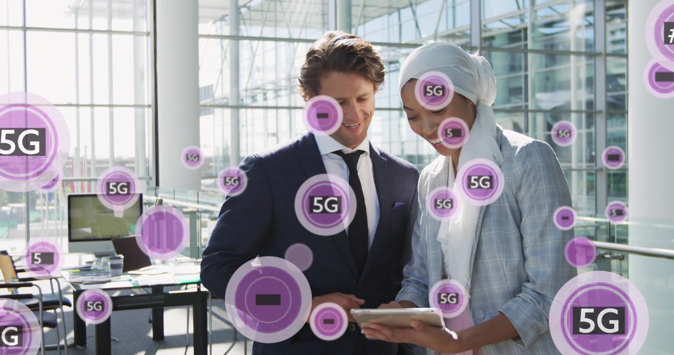 Animation of 5g text banners against diverse businessman and businesswoman using tablet at office