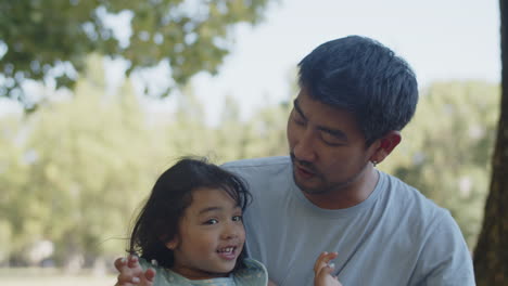 pequeña hija feliz besando al padre en la mejilla y al hombre tomando fotos