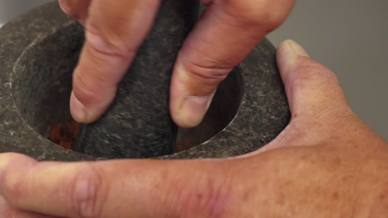 이 장면에서 일부 천연 식물 추출물은 집에서 만든 진의 맛을 내기 위해 유봉과 박격포로 갈고 있습니다.