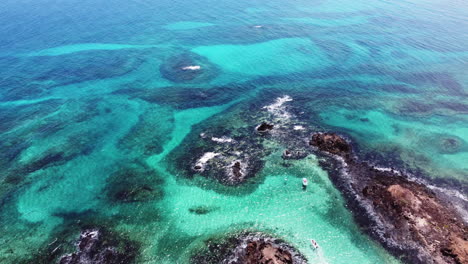 Aguas-Turquesas-Y-Pequeñas-Embarcaciones-Rodeando-La-Isla-De-Los-Lobos