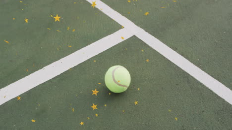 single tennis ball resting on green court surface, being framed by white lines and golden stars