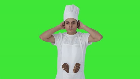 un cocinero profesional indio serio se está preparando pantalla verde