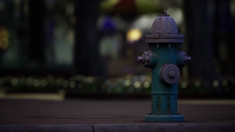 hydrant stands alone under soft light in a quiet urban setting at night
