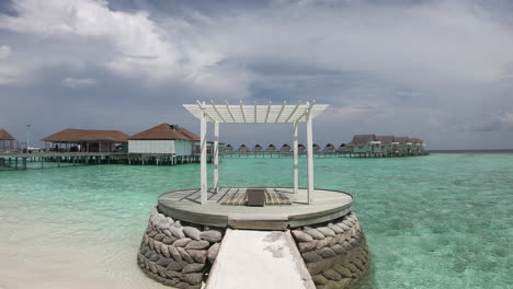 arco blanco con bungalow y fondo marino en maldivas