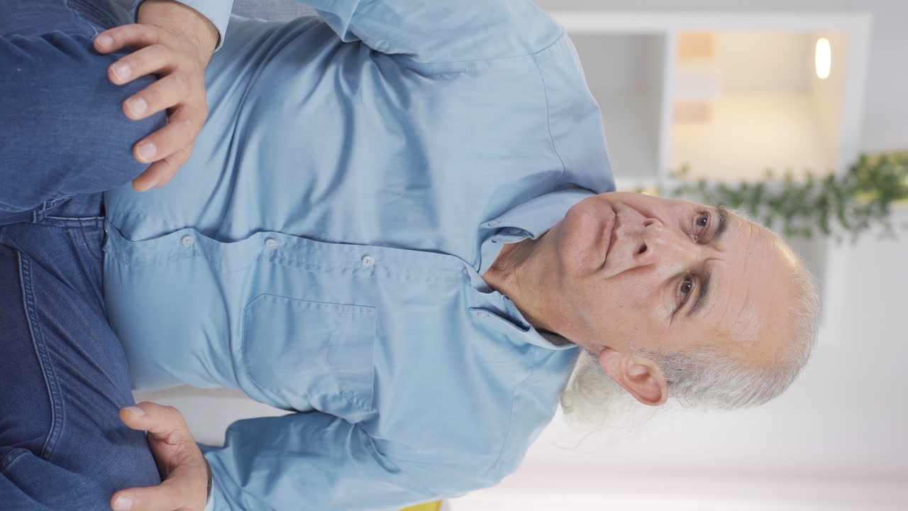 Vertical video of Paranoid old man looking around at home.