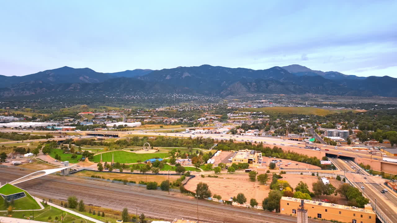 Colorado Springs, USA, 22 July 2025: Rising over the vast panorama of Colorado-Springs, Colorado, USA. Many cars move by the roads. Mountain range at backdrop