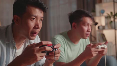 Asian Friends With Joystick Playing Video Games At Home