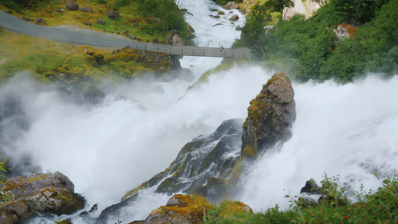 el viajero admira el tormentoso río de montaña que se origina en el glaciar briksdal la majestuosa escena