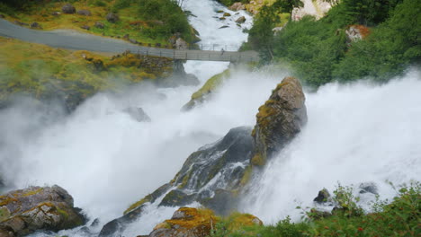 el viajero admira el tormentoso río de montaña que se origina en el glaciar briksdal la majestuosa escena