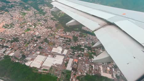 Schuss-Aus-Einem-Flugzeugfenster,-Während-Er-Tagsüber-über-Eine-Stadt-Fliegt