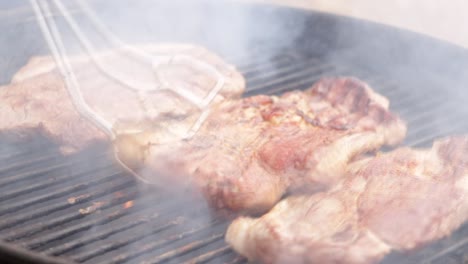 flipping steaks on a grill