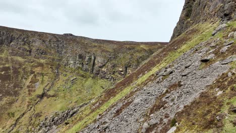 Ireland-Waterford-Comeragh-Mountains-Mahon-Falls-drone-fly-over-steep-ground-under-the-cliffs-to-the-waterfall-on-a-cold-spring-morning