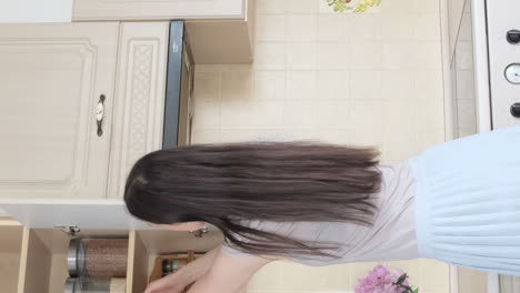 Woman in kitchen opening cabinets