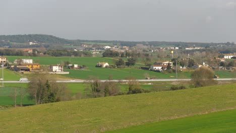 Schönes-Grünes-Feld,-Das-Gerade-Mit-Blauem-Himmel-Und-Bäumen-Im-Hintergrund-Und-In-Den-Bergen-Gesät-Wurde