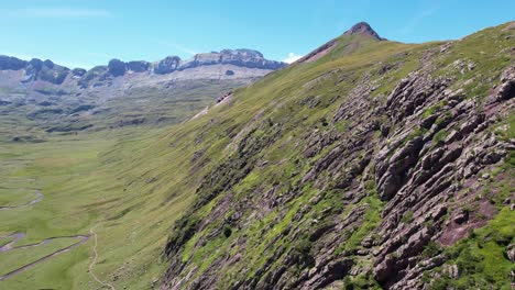 Grandes-Paredes-De-Roca-Empinadas-Con-Un-Río-Serpenteante-En-El-Valle-Entre-Las-Grandes-Montañas-Del-Valle-De-Hecho-Y-En-España-Cerca-De-Huesca-En-Un-Día-Soleado-De-Verano