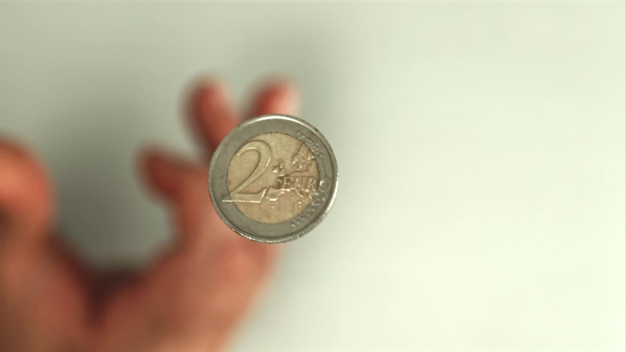 Primo piano di una moneta da 2 euro che gira al rallentatore