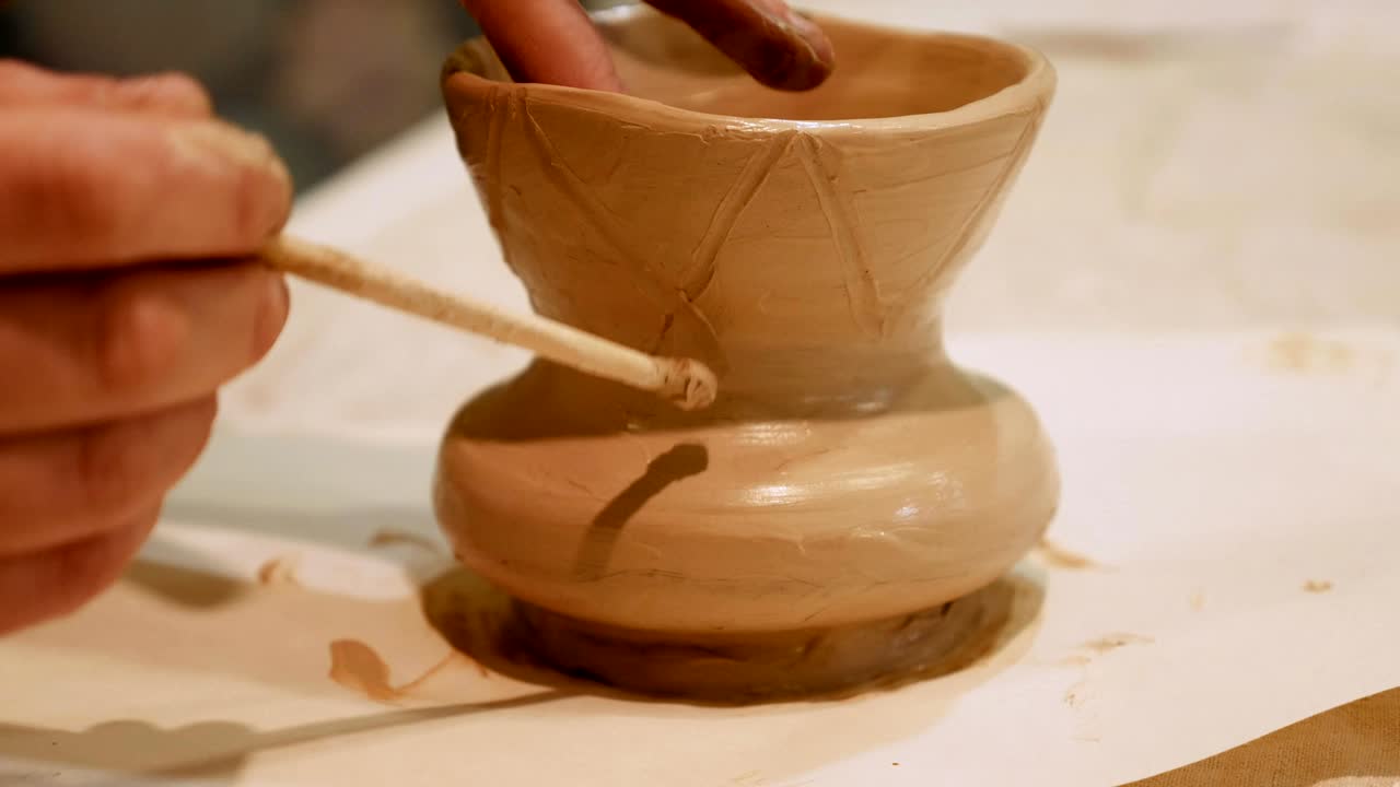 Il vasaio sta modellando un vaso di argilla al tornio