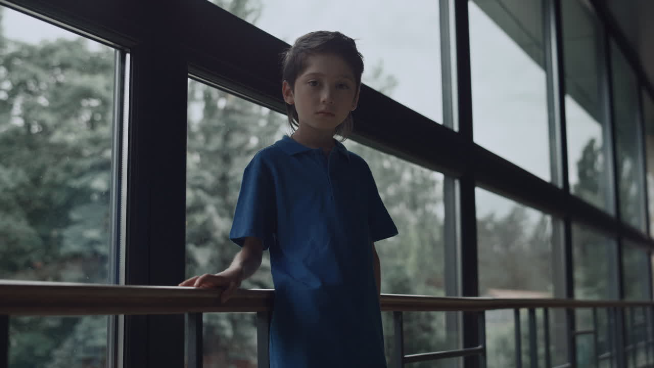 클로즈업 아이 얼굴이 불행하게 카메라를 바라보고 있습니다. 십대 학생이 홀에서 혼자 포즈를 취하고 있습니다.